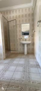 a bathroom with a sink and a glass shower at Eli Ndatis Self Catering Apartments in Kololi