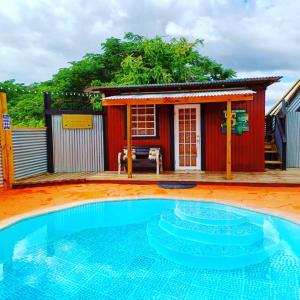 a small red house with a swimming pool in front of a house at Cabin by the Pool 