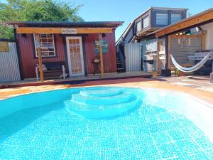 a swimming pool with a swing and a house at Cabin by the Pool 