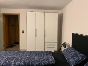 um quarto com uma cama e um grande armário branco em Ferienwohnung Maryna em Zwönitz