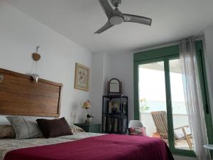 een slaapkamer met een bed en een plafondventilator bij 1ª línea mejor playa de Mojacar in Mojácar