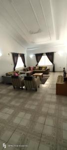 a living room with couches and tables in a room at Eli Ndatis Self Catering Apartments in Kololi