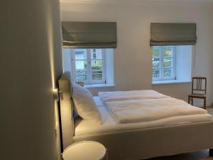 - un lit dans une chambre avec 2 fenêtres dans l'établissement Weberwinkel, à Monschau