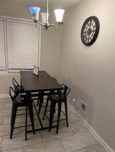 a dining room table with chairs and a clock on the wall at Amir Travels in Atlanta