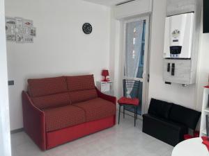 uma sala de estar com um sofá vermelho e uma cadeira em Il Melograno em Gallarate
