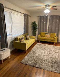a living room with two yellow couches and a rug at Amir Travels in Atlanta