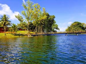 een brug over een waterlichaam met bomen bij Hacienda Alajuela in Colón