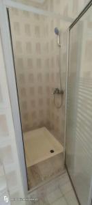 a shower with a glass door in a bathroom at Eli Ndatis Self Catering Apartments in Kololi