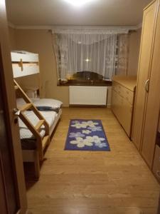 une petite chambre avec deux lits superposés et un tapis dans l'établissement SISI Domček, à Veľká Franková