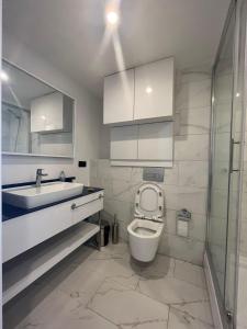 a bathroom with a toilet and a sink and a shower at Apart Otel Orbi City in Batumi