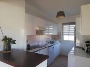 a kitchen with white cabinets and a sink at Résidence Stella Maris in Antibes