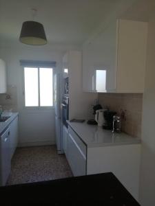 a kitchen with white cabinets and a counter top at Résidence Stella Maris in Antibes