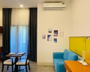 a living room with a blue couch and a table at Khem Beach serviced apartment in Phú Quốc