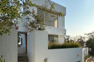 een wit huis met een hek en een paraplu bij Sunny 2-Story Loft w Ocean Views & Infinity Pool! in Sayulita