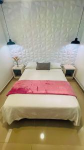 a large bed in a room with two tables at Kromatic Hostel in Medellín