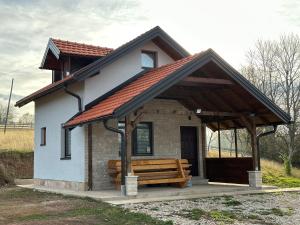 une petite maison avec un banc devant elle dans l'établissement Snjezna kuca Rakovac, à Pale