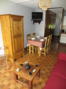 ein Wohnzimmer mit einem Tisch und einem Esszimmer in der Unterkunft Appartement serre chevalier 1200 in Briançon