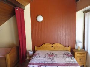 ein Schlafzimmer mit einem Bett und einer roten Wand in der Unterkunft Appartement serre chevalier 1200 in Briançon