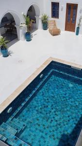 a swimming pool in the middle of a house at Maison d’hôte, Djerba 