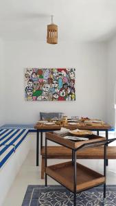 una mesa en una habitación con un cuadro en la pared en Maison d’hôte, Djerba 