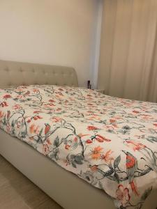 a bed with a flowered comforter on it at Modern 1 Bedroom Apartment Yas island with private beach in Abu Dhabi