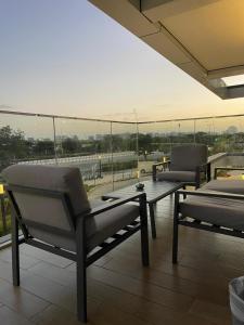 a patio with two chairs and a table on a roof at Modern 1 Bedroom Apartment Yas island with private beach in Abu Dhabi