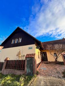 a house with a black roof and a fence at Vila Morava in Liptovský Mikuláš