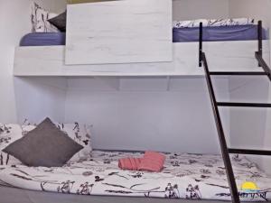 ein Schlafzimmer mit einem Etagenbett mit einer Leiter in der Unterkunft First Row to the sea Mobilehome in Drage