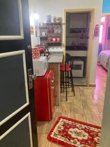 Apartamento aconchegante no Hotel Quitandinha com vaga de garagem في بتروبوليس: مطبخ مع ثلاجة حمراء بجانب كونتر
