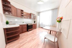 a kitchen with wooden cabinets and a table with a vase of flowers at Европейская 17 Мост сити Центр in Dnipro