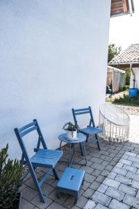2 sillas azules y una mesa en el patio en Stilvolles kleines Ferienhaus mit Garten, 