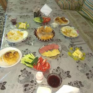 uma mesa com muitos pratos de comida em Janat Family Guesthouse em Karakol