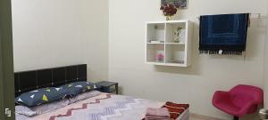 a bedroom with a bed and a white cabinet at Rawynaa Segamat Homestay in Buluh Kasap