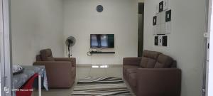 a living room with two chairs and a couch at Rawynaa Segamat Homestay in Buluh Kasap
