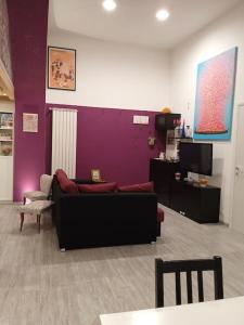 sala de estar con sofá y pared púrpura en PURPLE HOUSE, en Roma
