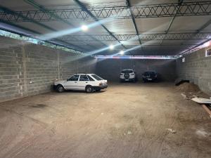 uma garagem com três carros estacionados nela em bedroom and private bathroom Habitacion y baño privado - en una casa em Córdoba