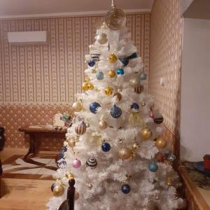 een witte kerstboom met versieringen erop bij Vana-Vastseliina külalistemaja in Illi