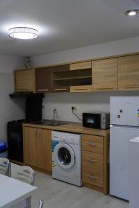 eine Küche mit einer Waschmaschine und einem Kühlschrank in der Unterkunft Casa Calin in Câmpulung Moldovenesc