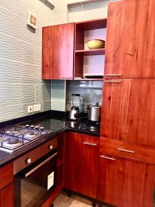 a kitchen with wooden cabinets and a stove top oven at Adepa Court Luxury Apartment Services in Kumasi