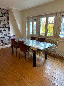 een eetkamer met een glazen tafel en stoelen bij Beau F3 - Proche Gare in Mulhouse