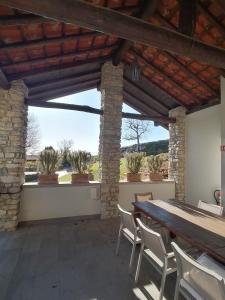 an outdoor patio with a wooden table and chairs at Casale Raffaello B&B Como in Albese Con Cassano