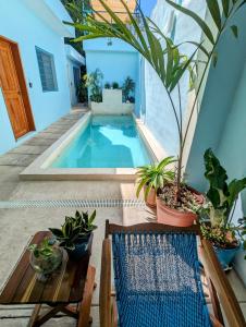 a swimming pool with a table and potted plants at Casa Aguazul in Campeche
