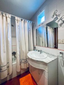a bathroom with a sink and a shower curtain at O Souto de Monteasnal in Ourense