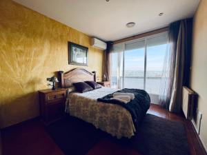 a bedroom with a large bed with a large window at O Souto de Monteasnal in Ourense