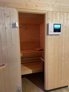 a sauna with a television in a wooden room at Golfchalet 3 confini in Tarvisio