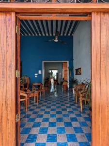 een kamer met blauwe muren en een vloer met stoelen en tafels bij Casa Aguazul in Campeche