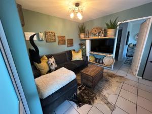 a living room with a couch and a tv at Serenity in Central in Knysna