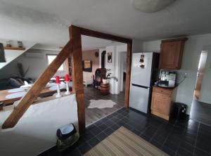 a room with a kitchen with a refrigerator and a table at Gemütliche 5Pers Ferienwohnung "Am Steinbach" Nürnberger Land Ruhig und gute Anbindung in Burgthann