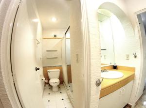 a bathroom with a toilet and a sink and a mirror at Beach & Ocean Front Apartments Brisas Cancun Zona Hotelera in Cancún