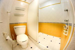 a bathroom with a toilet and a shower at Beach & Ocean Front Apartments Brisas Cancun Zona Hotelera in Cancún